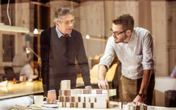 Zwei Architekten beraten sich zum Modell eines Neubaus