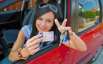 Junge Frau zeigt stolz ihren Führerschein
