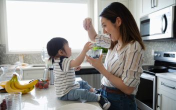 Frau scherzt mit kleiner Tochter in Küche